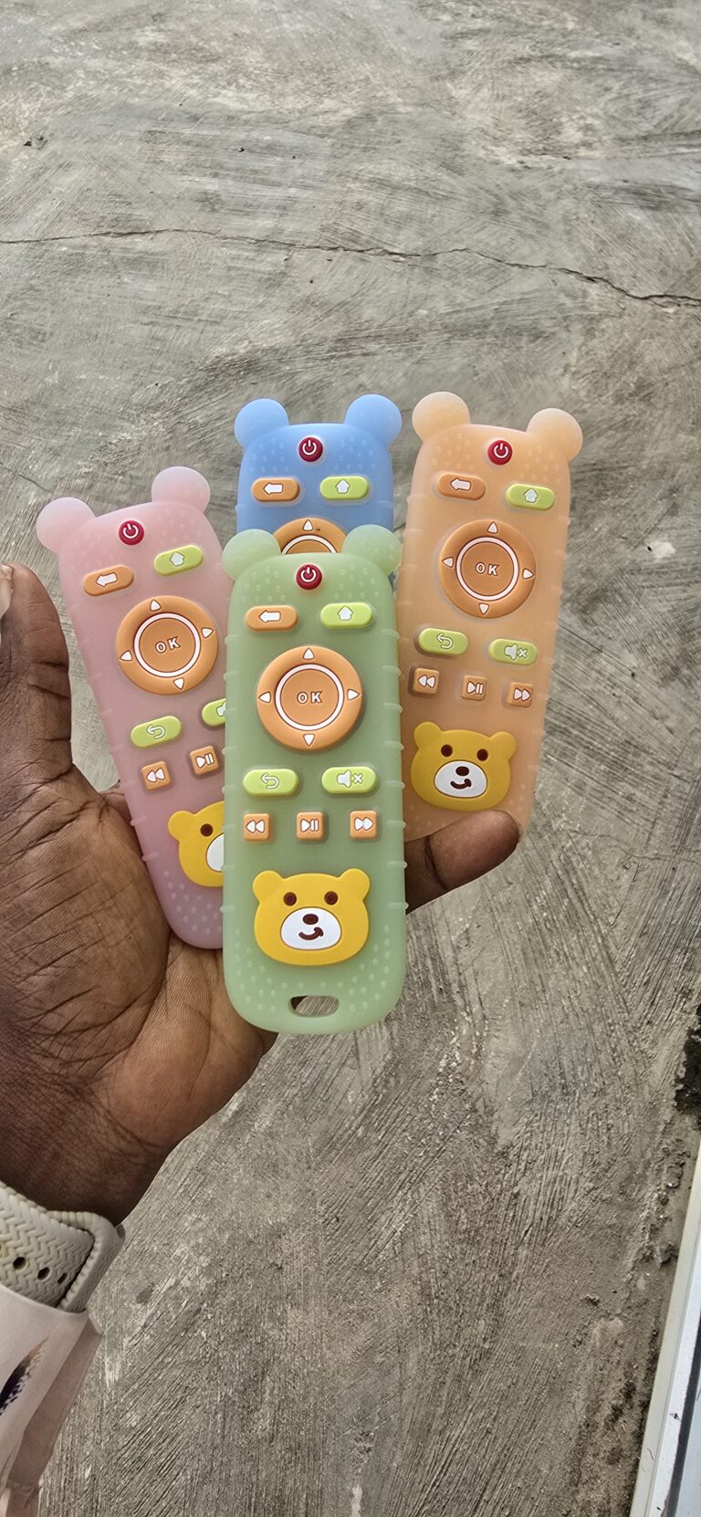 "Baby silicone remote control teether toy in pink, blue, green and orange bear design — safe for teething babies"